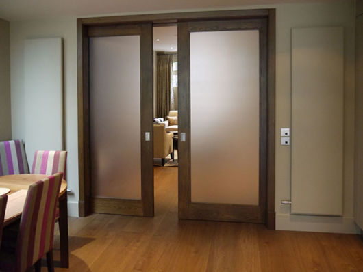 Ideia de sala com porta de correr com vidro fosco e esquadrias largas