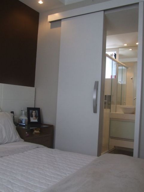 Quarto com porta de correr branca para a suíte