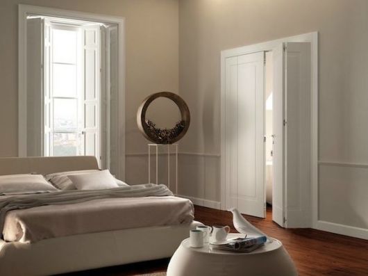 Quarto clean com porta sanfonada branca