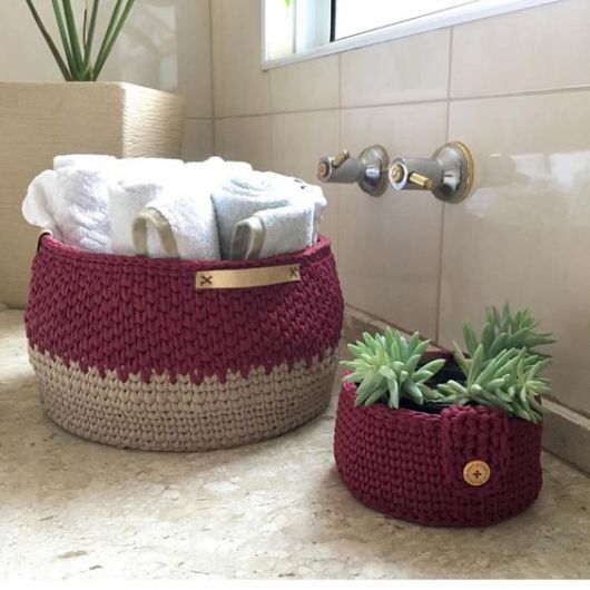 cesto de crochê com toalhas e vasinhos de plantas