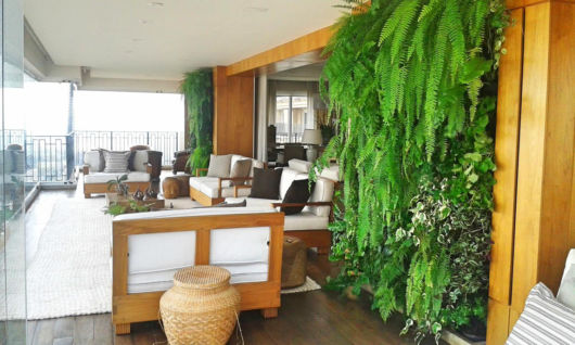 Jardim vertical em varanda de apartamento com samambaia
