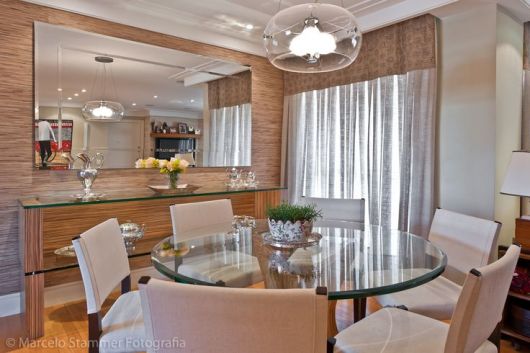 Sala de jantar com papel de parede e espelho grande