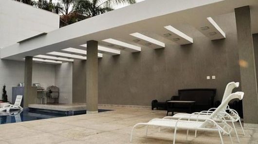 pergolado de concreto em área externa com piscina
