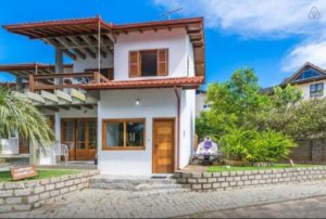 sobrado de alvenaria branco com portas de madeira.