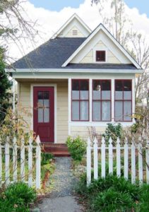 Casa branca com porta vermelho vinho.