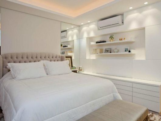 Decoração de quarto de casal branco com prateleiras