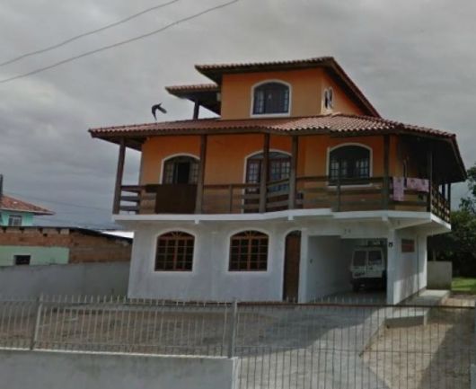 casa de dois andares com varanda na volta.