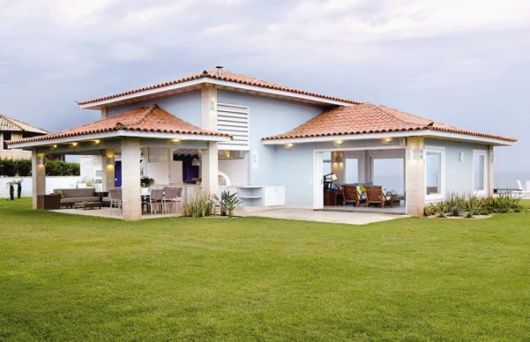 casa azul com varanda na volta.