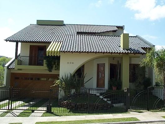 casa amarela com telhado aparente.