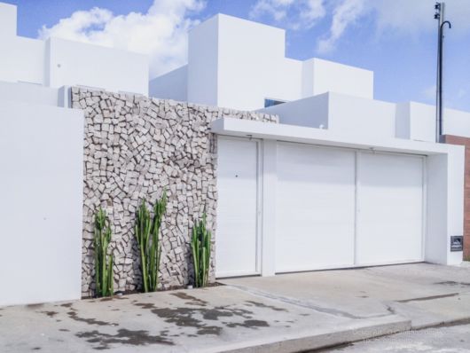 casa branca com muro na frente.