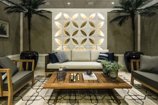 sala grande verde musgo com parede vazada branca ao fundo.