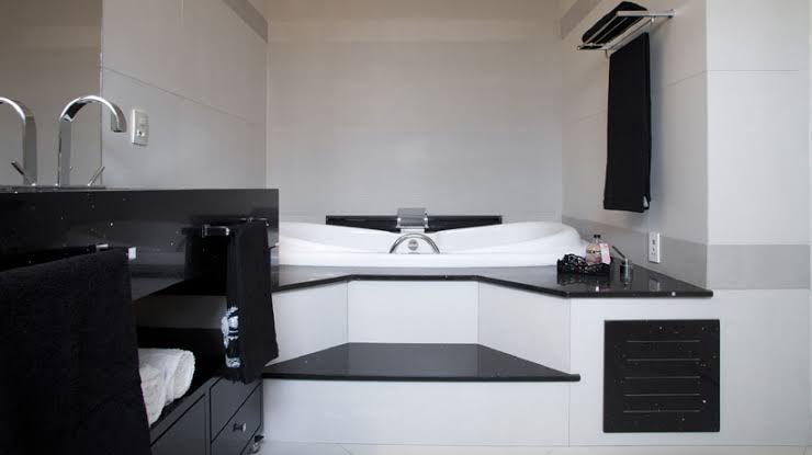 banheiro preto e branco com banheira pequena